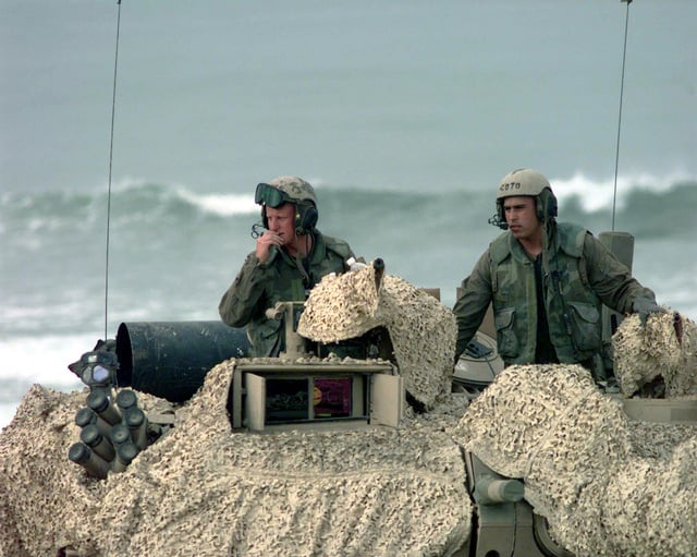 Marines aboard a camouflaged Abrams M1A1 Main Battle Tank (MBT) prepare ...