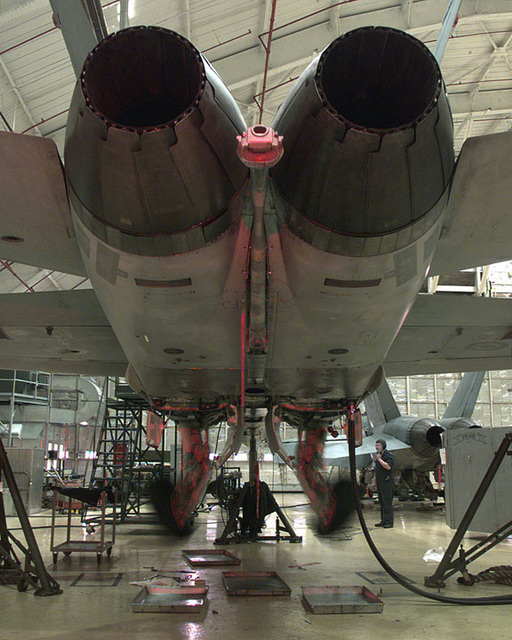 The landing gear assembly of a CF-18 Hornet is blurred as technicians ...