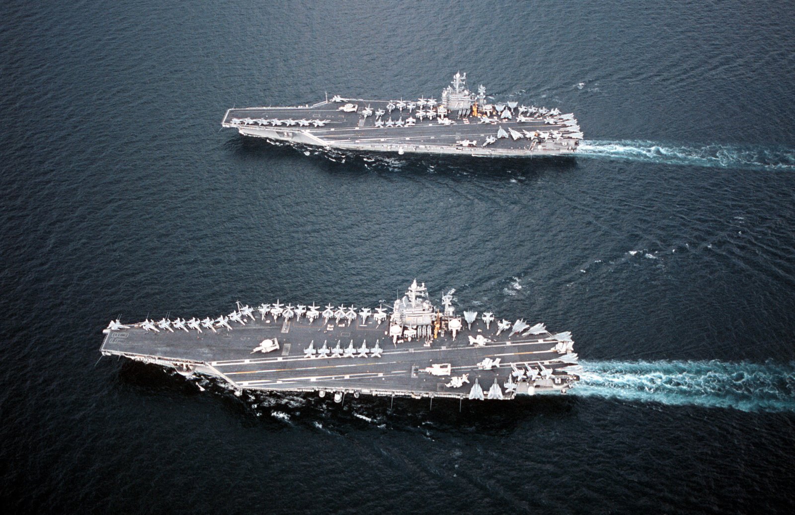 The aircraft carrier USS NIMITZ (CVN 68) (bottom) comes alongside the ...