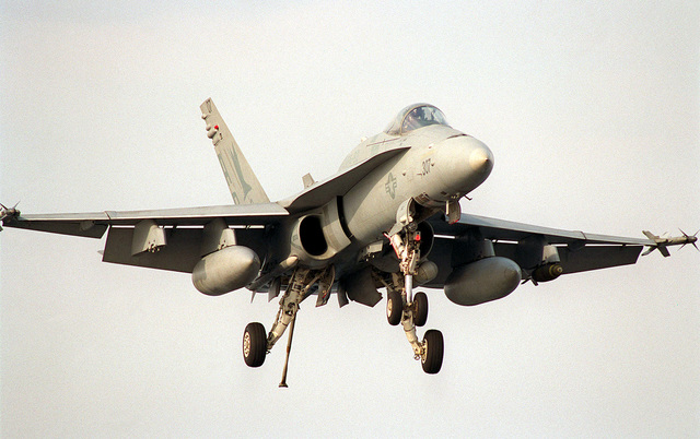 An F/A-18 Hornet glides in for a landing on the flight deck of USS ...