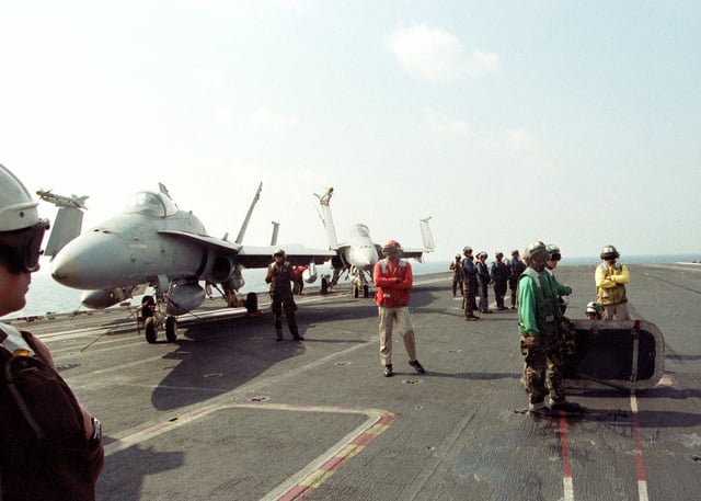 US Navy flight deck personnel await the next launch/recovery cycle ...