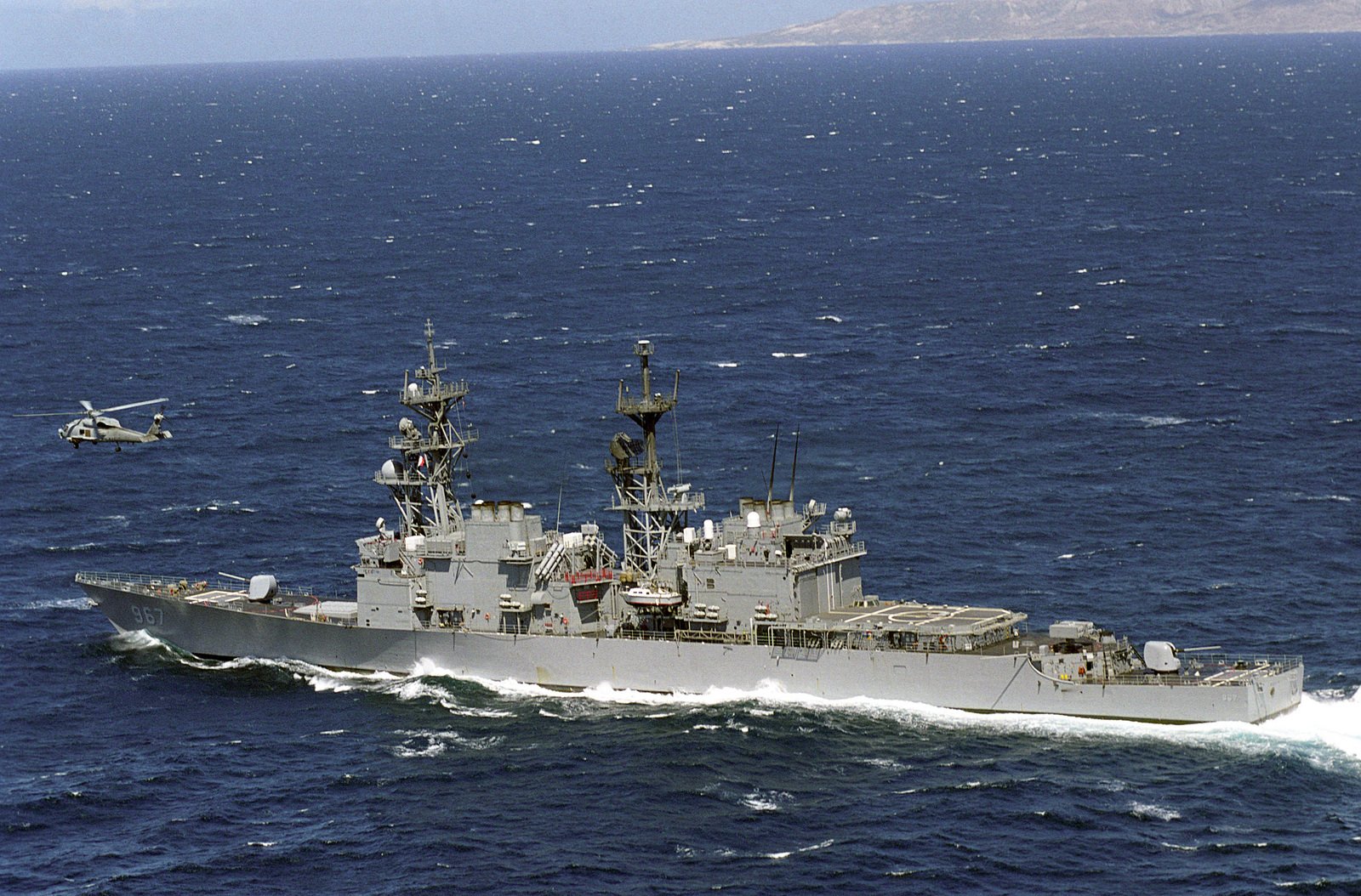 an-aerial-portside-view-of-the-spruance-class-destroyer-uss-elliot-dd-967-with-an-sh-60