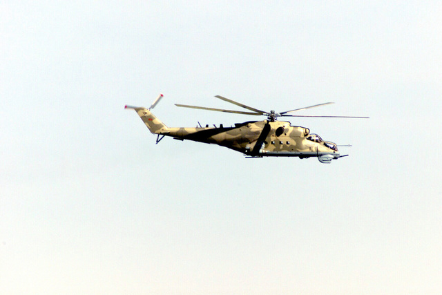 A Russian made Mi-24 Hind Helicopter Flies over the battlefield during ...