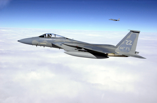 An air-to-air left side view of an F-15C Strike Eagle aircraft from the ...