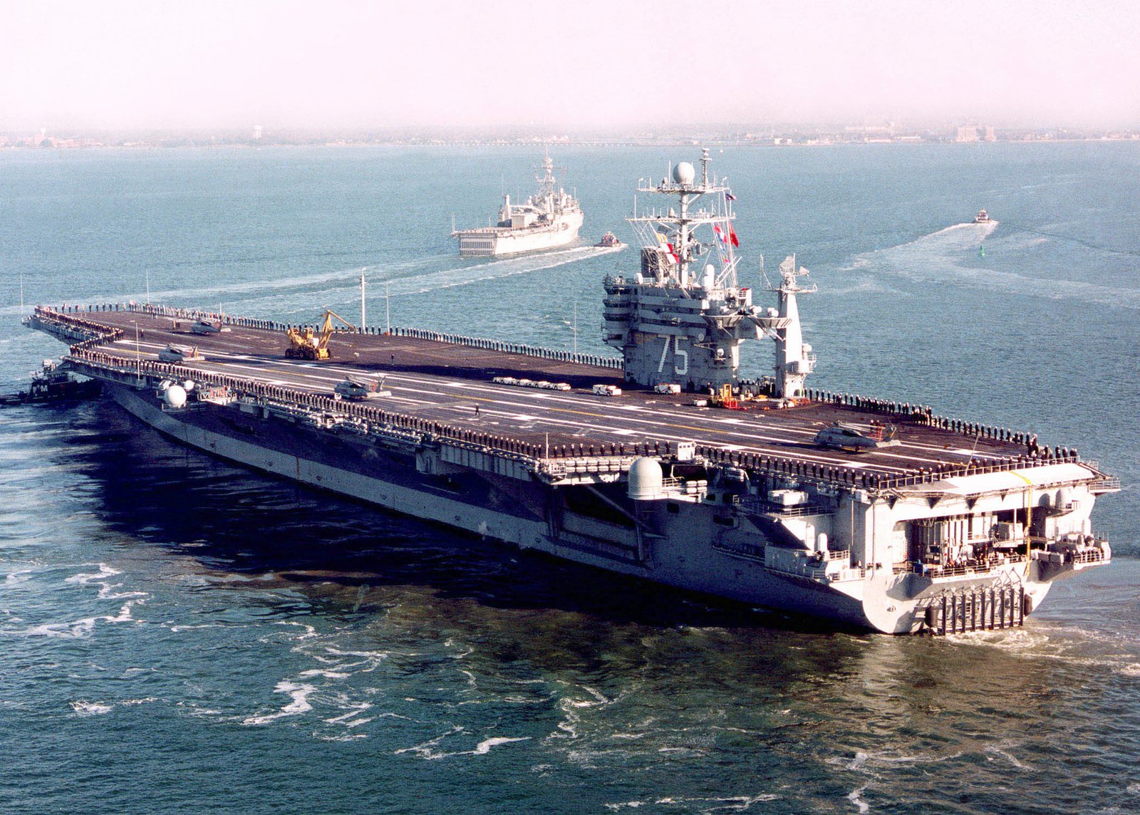 Sailors stationed aboard the USS HARRY S. TRUMAN (CVN 75) man the rails ...