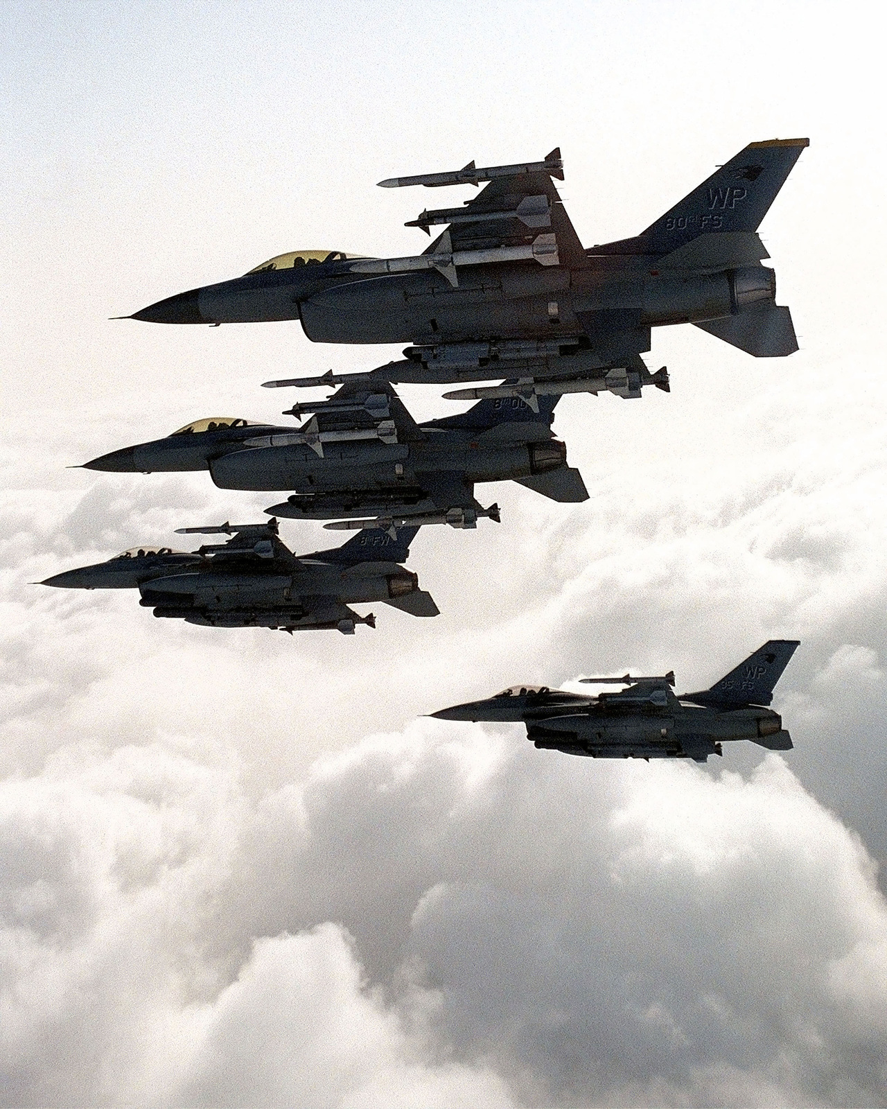 An aerial view of a four-ship wedge formation of US Air Force F-16C ...