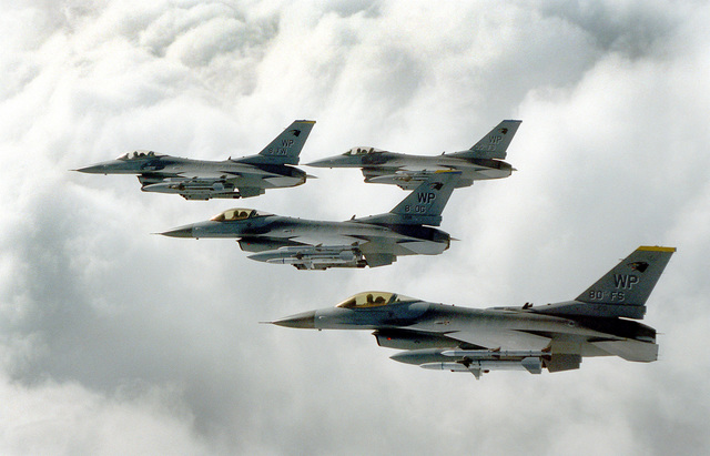 An aerial view of a four-ship wedge formation of US Air Force F-16C ...