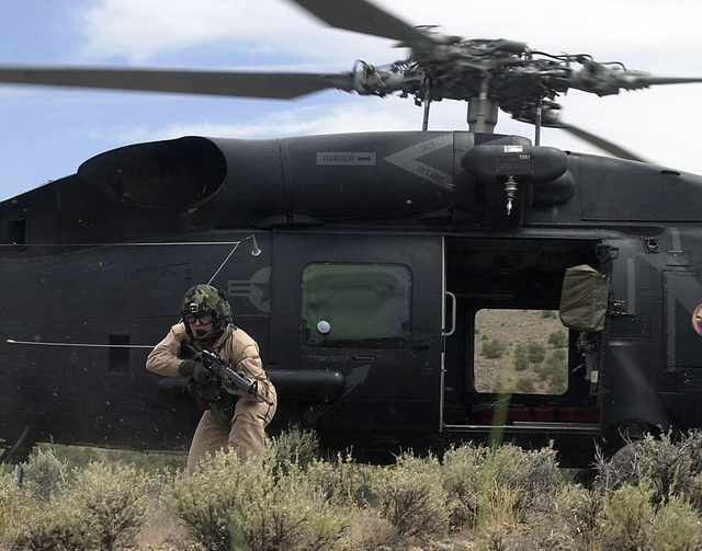 Navy personnel in a HH-60H Seahawk helicopter move in with M-4 Carbine ...