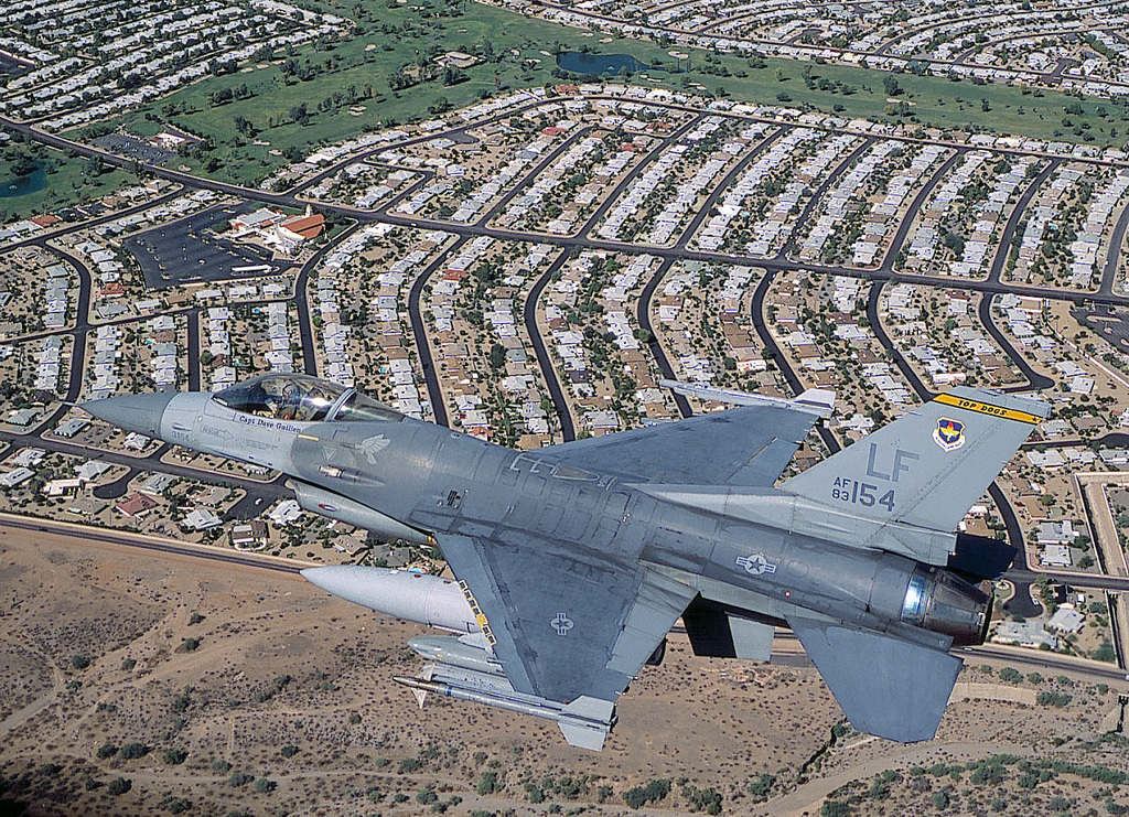 An F-16C Fighting Falcon, 308th Fighter Squadron, Luke AFB, Arizona, flies  over a housing area as it heads back to base after a local training  mission. The F-16 is carrying two AIM-9