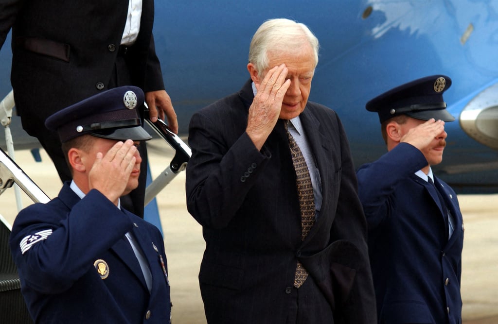 Former US President James E. Carter, Jr. renders a salute upon arriving