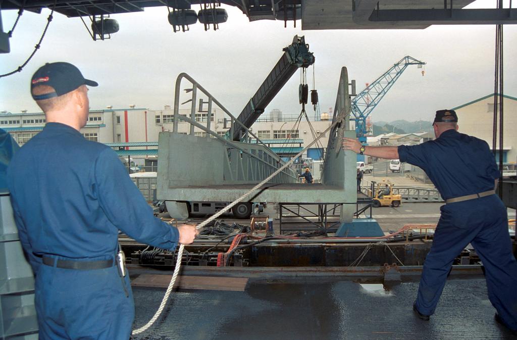 US Navy Engineman 2nd Class Anthony Bartelli (right) holds an