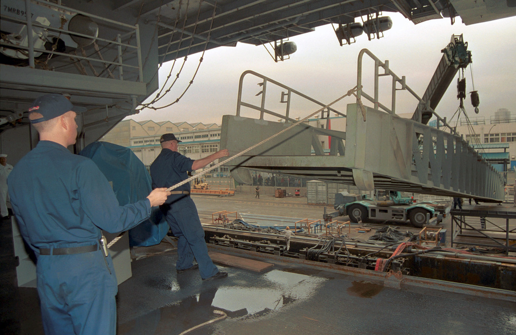 US Navy Engineman 2nd Class Anthony Bartelli (right) holds an