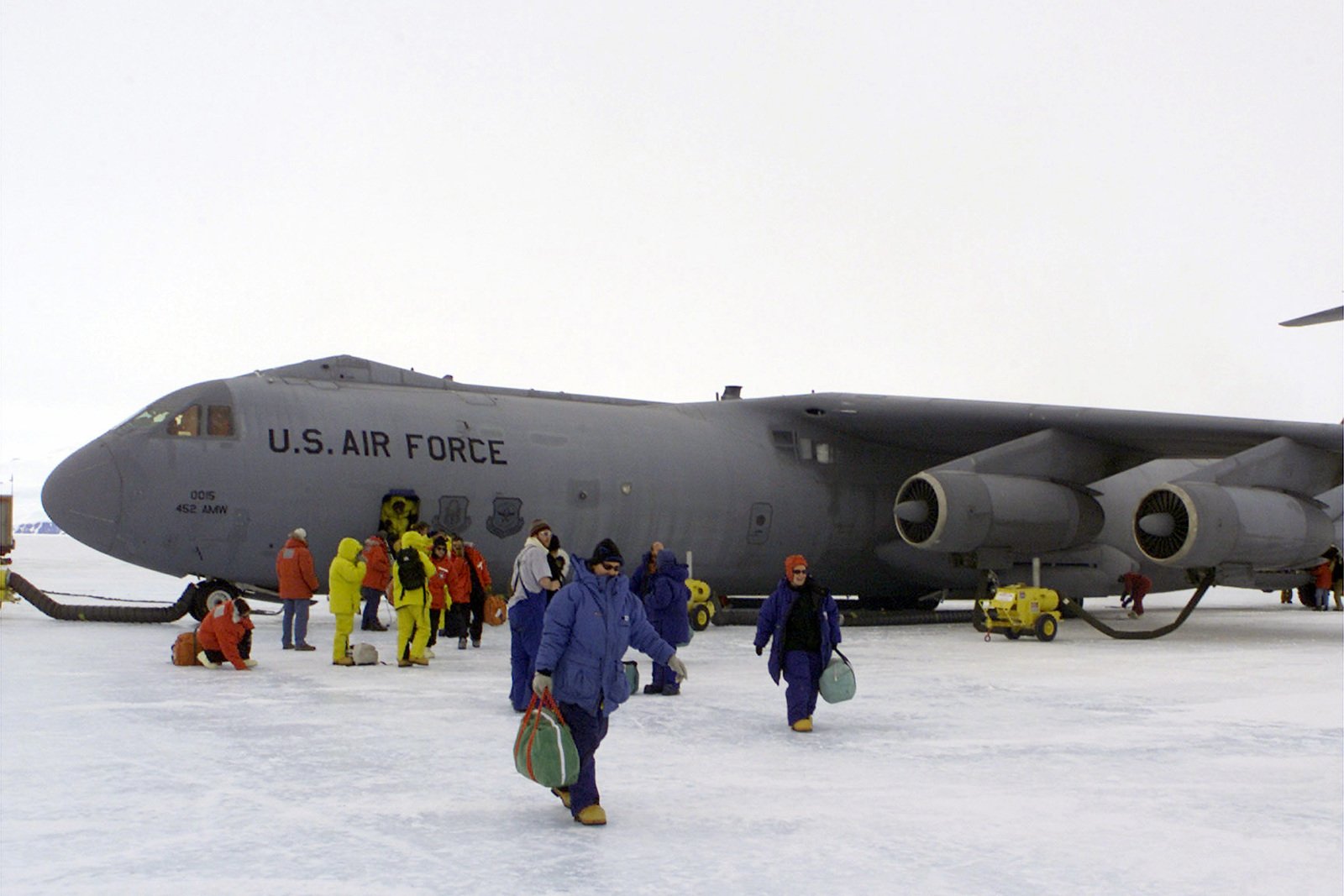 Scientist, passengers and support personnel deplane a Lockheed C-141C ...