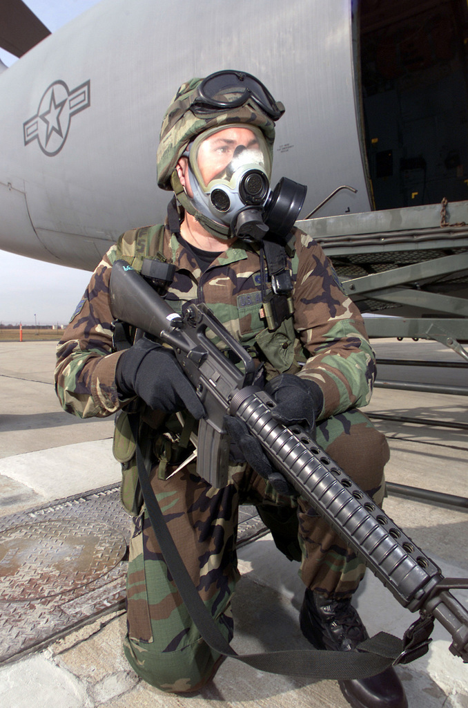 Armed with Colt 5.56 mm M16A2 rifles and wearing MCU-2P Gas Masks, a ...