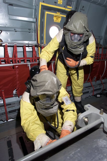 Inside a C-141 Starlifter, airmen in MCU-2P Gas Mask with self ...