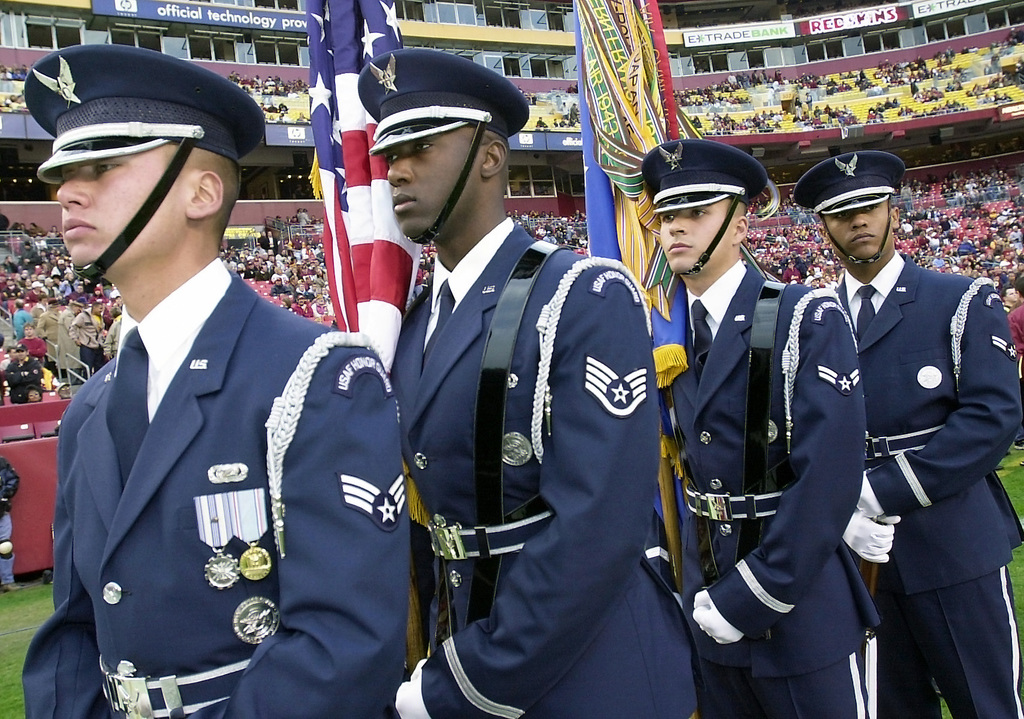 U.S. service members with the RAF Molesworth Honor Guard uncase the colors  of the American flag before the start of the International Series, Miami  Dolphins versus New York Jets NFL game at