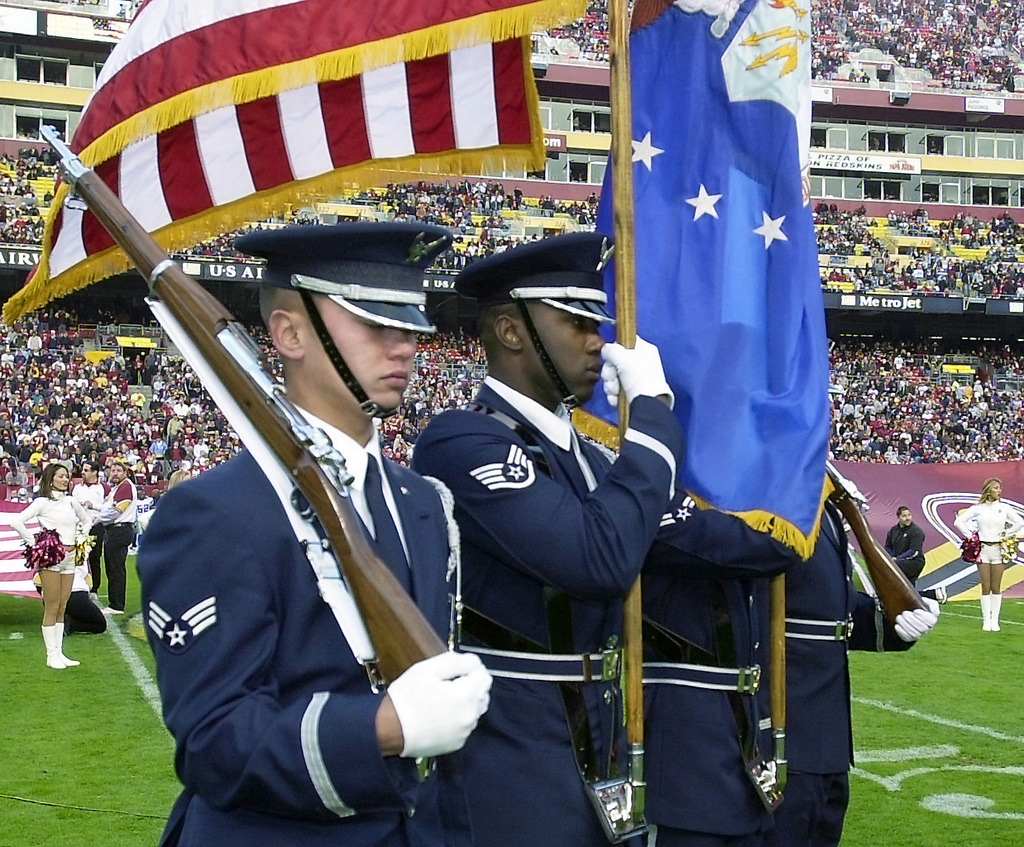 U.S. service members with the RAF Molesworth Honor Guard uncase the colors  of the American flag before the start of the International Series, Miami  Dolphins versus New York Jets NFL game at