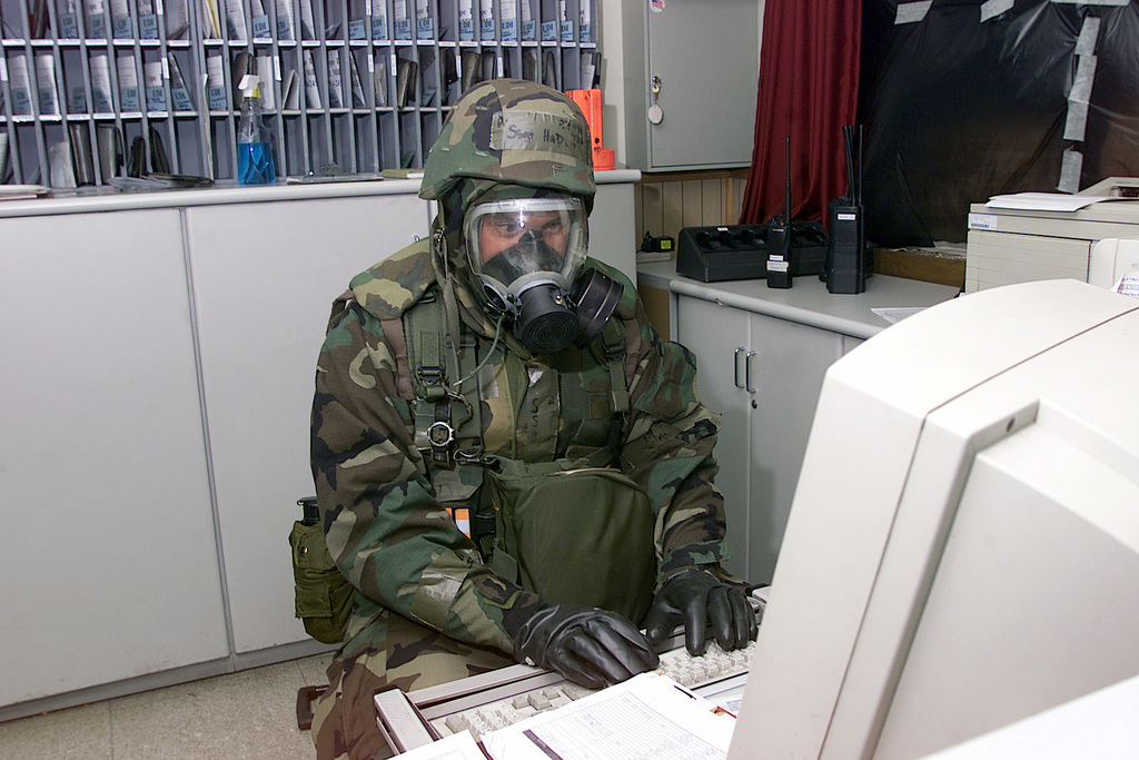 Two Soldiers from Task Force 3330, 3rd Special Forces Group (Airborne),  teach a class on how to properly remove MOPP (Mission-Oriented Protective  Posture) gear in the event of a simulated CBRN (Chemical