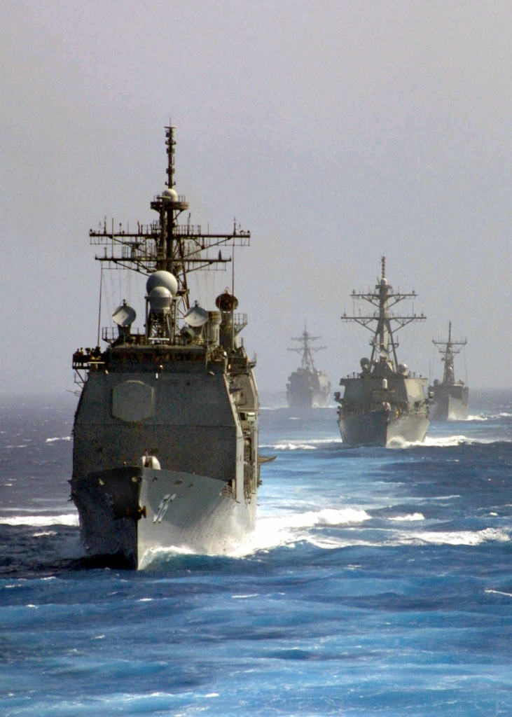 An armada of US Navy USN Ships steam in formation during an