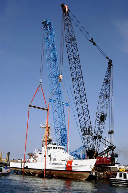 Two heavy lifting cranes are used to lift the US Coast Guard (USCG ...