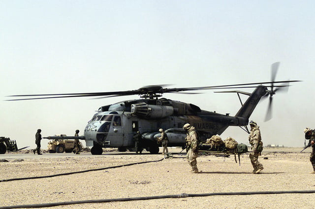 Two US Marine Corps (USMC) Marines from Jalibah Air Base, Iraq carry ...