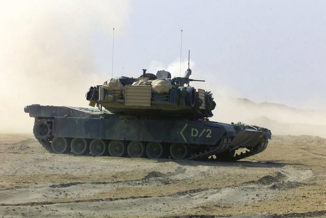 An M1A1 Abrams Main Battle Tank (MBT) maneuvers in order to fire during ...