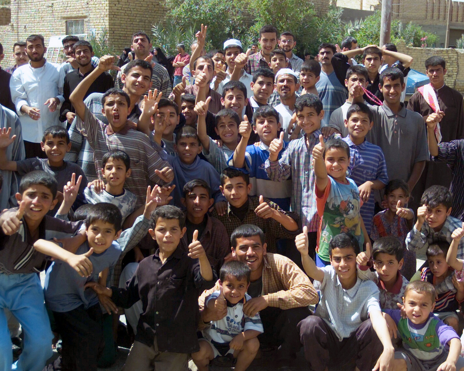 Local children wave to the US Marine Corps (USMC) cameraman in Al Hay ...