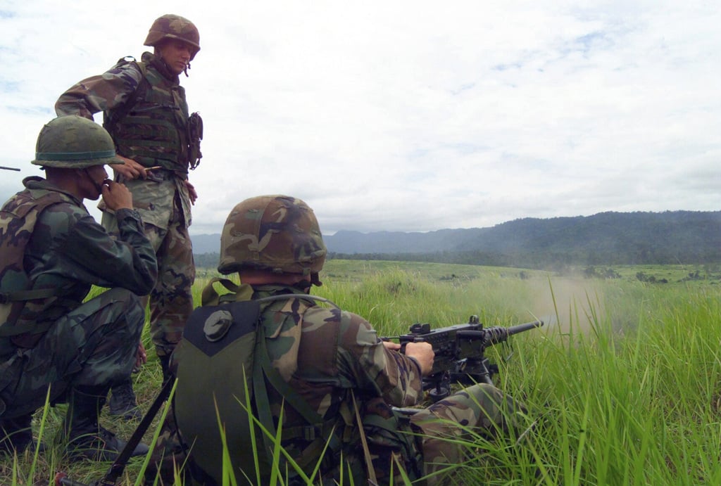 US Marine Corps (USMC) Sergeant (SGT) Shannon Sass (standing) watches ...