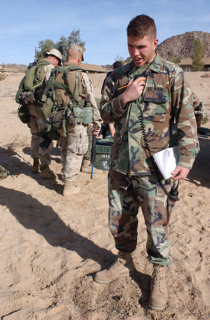 US Marine Corps (USMC) Corporal (CPL) Douglas C. Martin, Alpha/Company, 1ST  Battalion 7th Marines, keys the handset on his field radio, at a Simunition  gear check station, as Marines assigned to 3rd