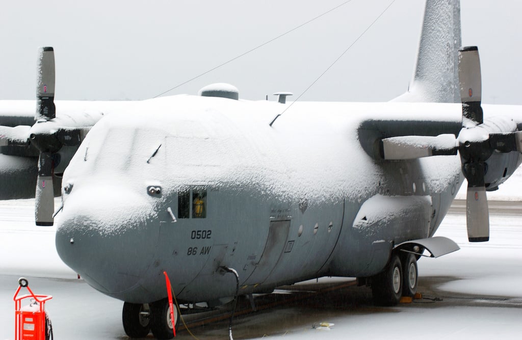 In a falling snow, a US Air Force (USAF) C-130 Hercules aircraft sits ...