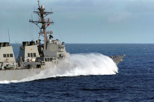 Waves crash over the starboard bow of the US Navy (USN) Arleigh Burke ...