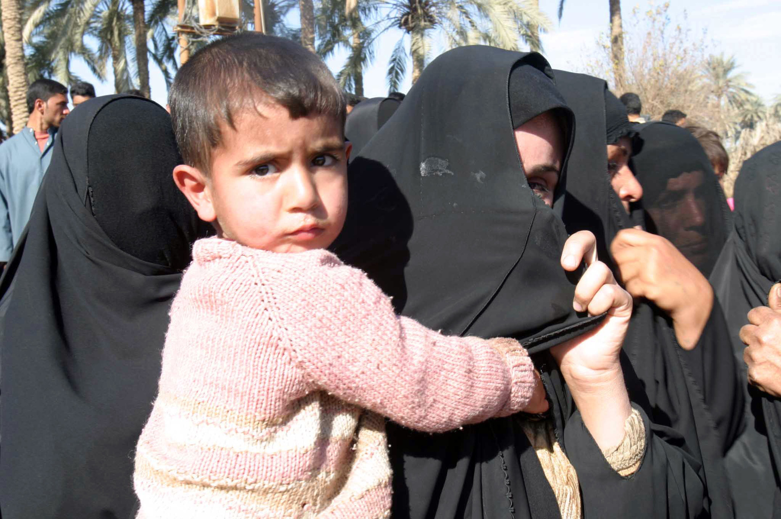 An Iraqi woman covers her face for the camera after she encourages the ...