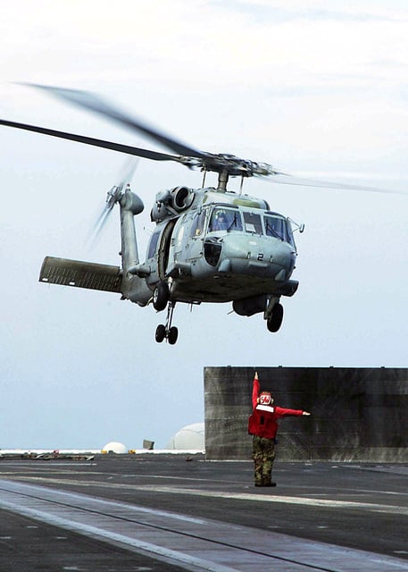 A Landing Signals Enlisted (LSE) Sailor launches a US Navy (USN) SH-60F ...