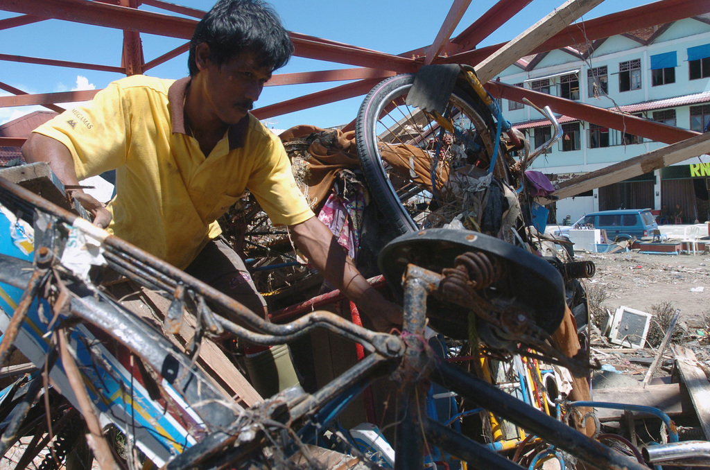 An Indonesian Man Sifts Through The Rubble In The City Of Meulaboh