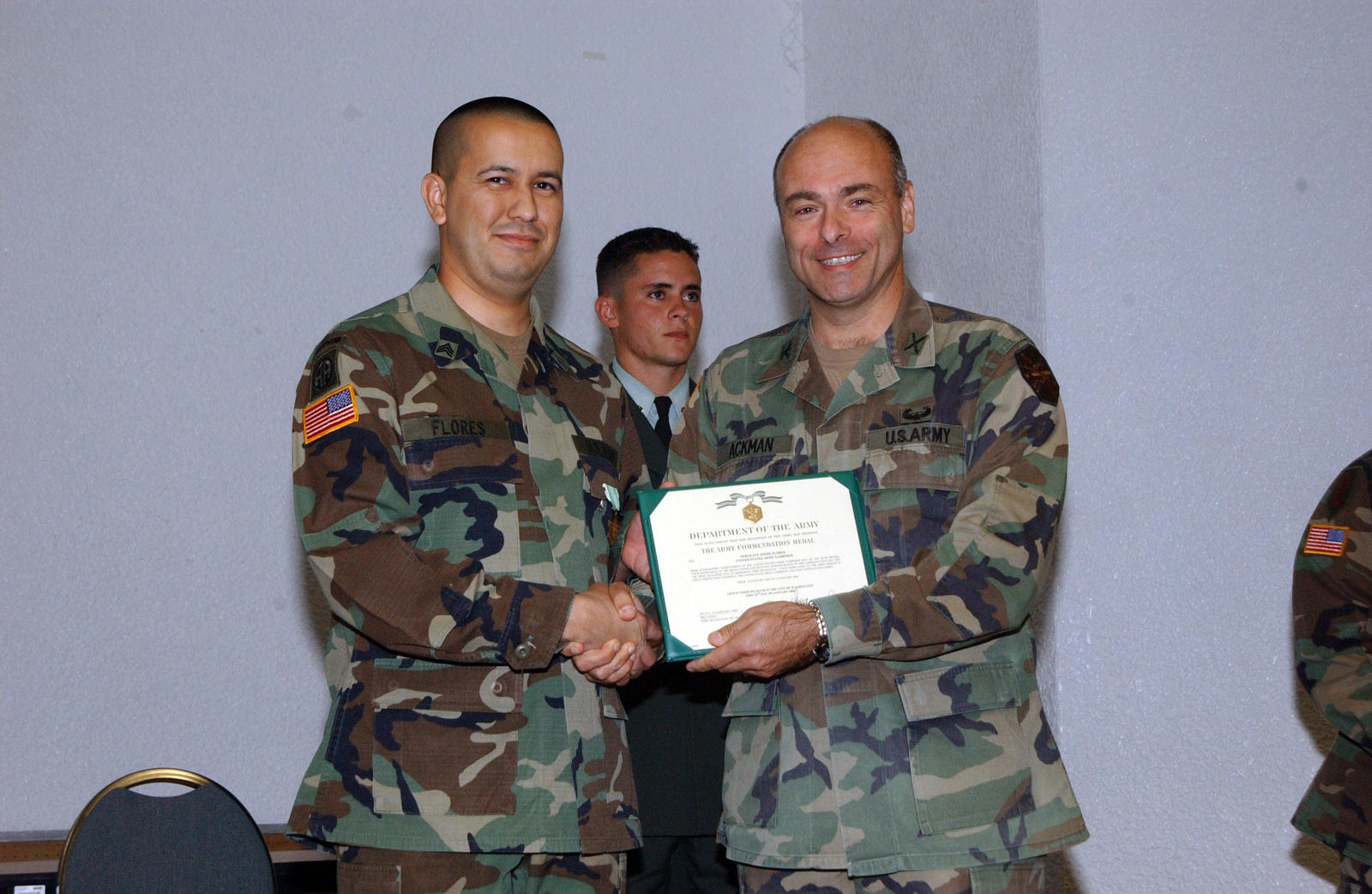 U S Army Garrison Commander Col Stephen M Ackman Presents The Commendation Certificate While Posing For The