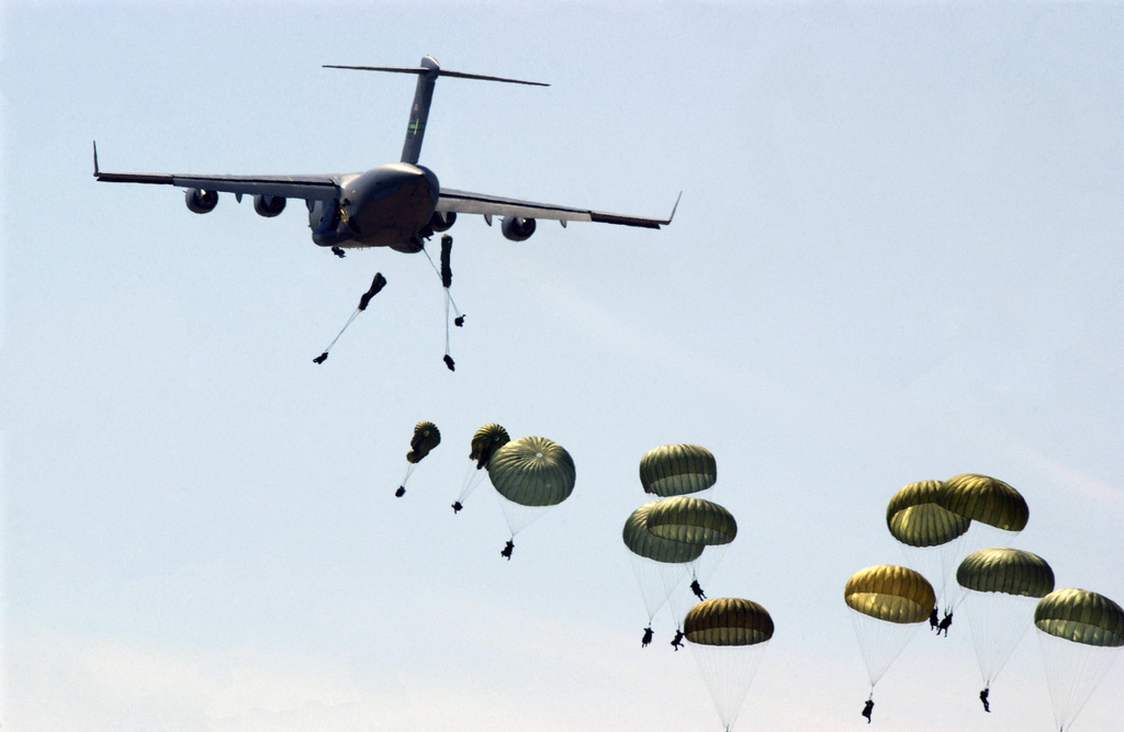 Army paratroopers jump from a C-17 Globemaster III aircraft during