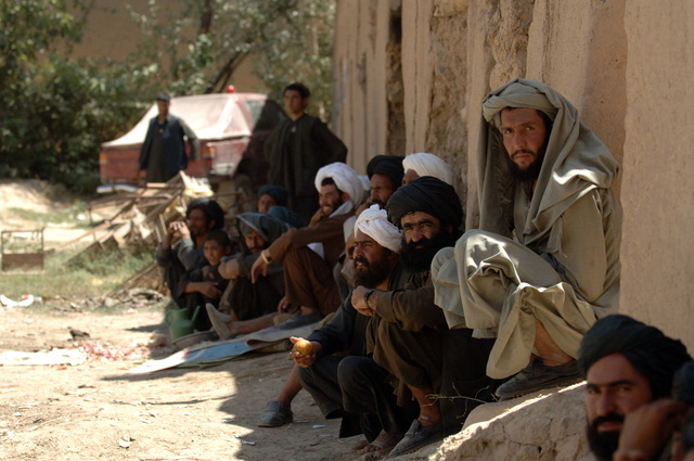 A group of Afghan locals listen to the loud speaker that was place ...