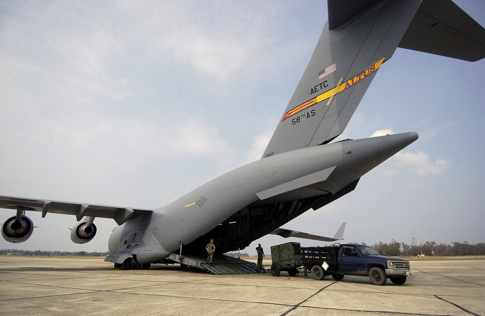 US Air Force (USAF) Airmen offload a portable generator from a C-17A ...