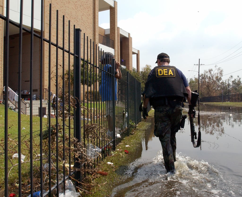 Hurricane Katrina] New Orleans, LA, September 3, 2005 -- Security personnel  escort FEMA Urban Search and Rescue task force members into neighborhoods  impacted by Hurricane Katrina. Jocelyn Augustino/FEMA - NARA & DVIDS