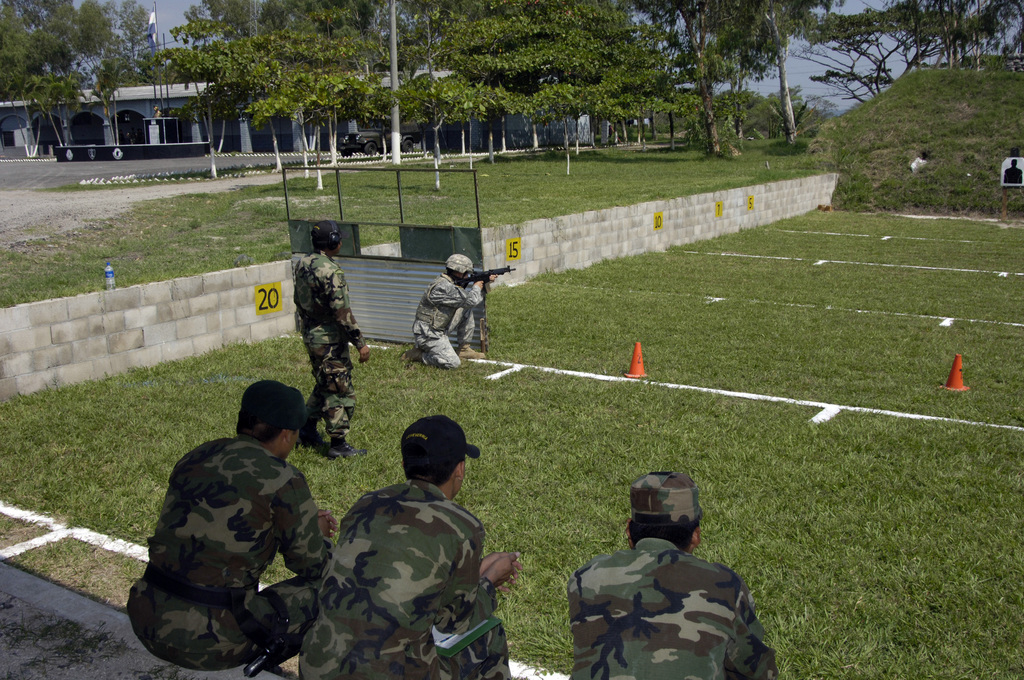 Soldiers from the El Salvador Army Parachute Battalion, seated, watch ...