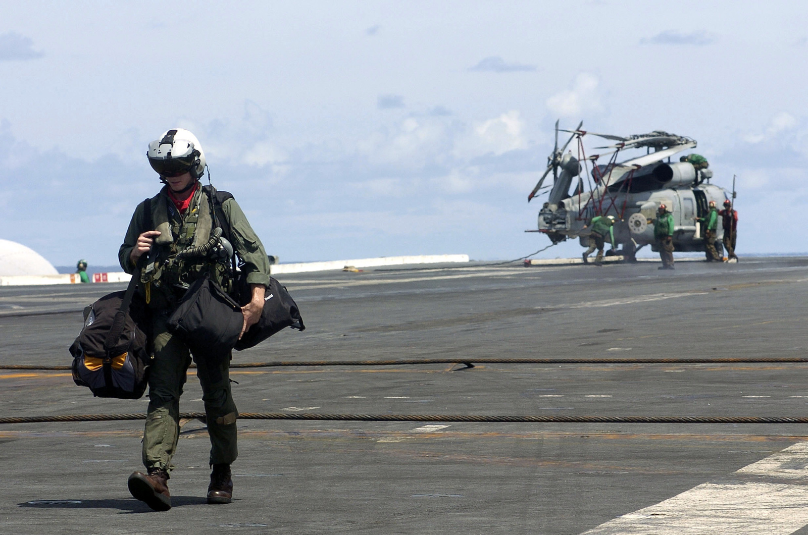 A U.S. Navy pilot from Strike Fighter Squadron 102 walks across the ...