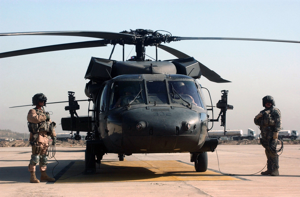 U.S. Army Crew Members of a UH-60 Balckhawk helicopter stand by at Camp ...