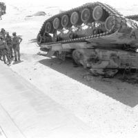 Marines gather beside an M-60A1 main battle tank fitted with