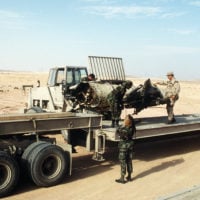 A crane is used to lift a canister containing a MIM-104 Patriot