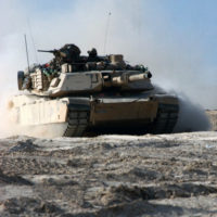 Marines gather beside an M-60A1 main battle tank fitted with